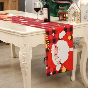 Red and black checkered Christmas table runner with Santa Claus print on a dining table