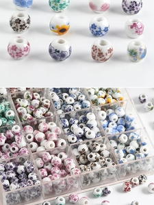 Macro shot of assorted ceramic beads with floral patterns in a clear storage box