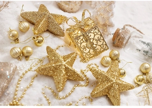 Close-up of golden Christmas tree topper star with assorted glitter ornaments and beads