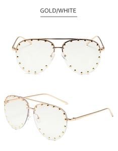 Close-up of gold aviator sunglasses with decorative rivets and clear lenses