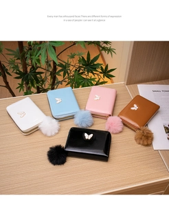 Flat lay of multiple colorful small wallets with butterfly clips and pompom charms