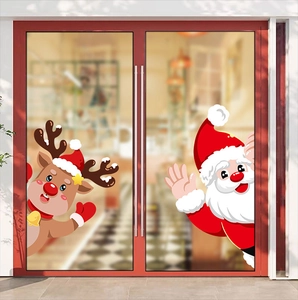 Christmas window decals showing Santa and reindeer stickers on glass door in warm indoor setting