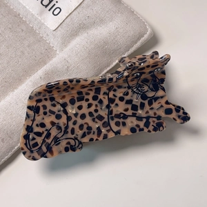 Detailed view of a leopard-shaped hair claw clip made of tortoiseshell acetate material