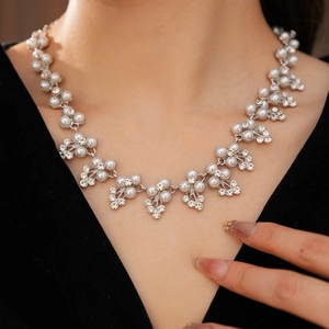 Gros plan d'un collier de mariée avec perles blanches et fleurs en strass étincelants