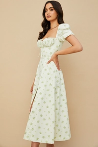 Detail of light green floral dress showing puff sleeves, drawstring neckline and side slit