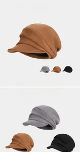 Detail of pleated faux suede beret hats in brown, grey and black colors