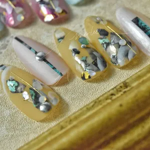 Macro shot of Japanese marble textured nail stickers with gold lines and shell inlay