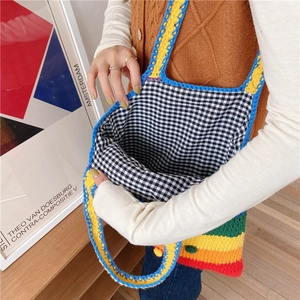 Detail of handmade rainbow knit tote bag showing colorful stripes and checkered lining