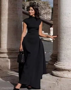 Detail of waist-slimming pleats and metal buckle on elegant black sleeveless maxi dress