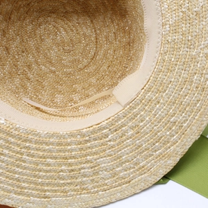 Détail intérieur d'un chapeau de paille avec bandeau et ruban gros-grain vert