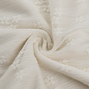 Close-up of white floral lace fabric showing delicate mesh texture and soft material