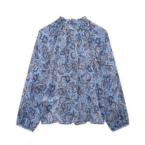 Dettaglio della camicetta in chiffon paisley blu con scollo a balze e colletto annodato