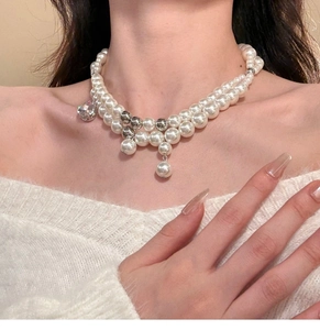 Detail of double-layer pearl necklace with zircon pendant on a model collarbone