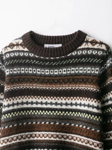 Close-up of Fair Isle geometric jacquard pattern on a brown knit wool sweater