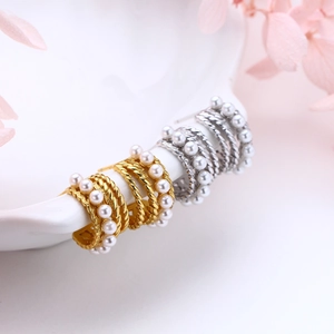 Detailed macro of vintage silver pearl twist C-shaped earrings on ceramic plate