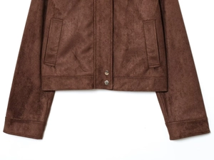 Detailed close-up of brown suede jacket hem with silver snap buttons and neat stitching