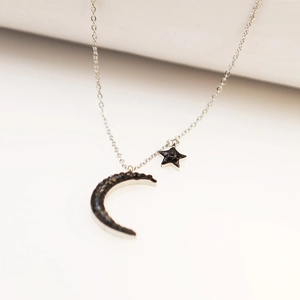 Silver star and moon pendant necklace with black rhinestones for women on white background
