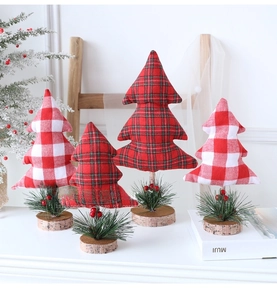 Close-up of handmade fabric Christmas trees with plaid patterns on wooden bases