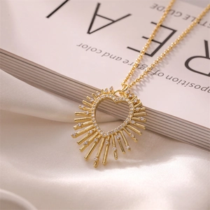 Detail of gold heart pendant with micro-pave zircons on elegant white silk background
