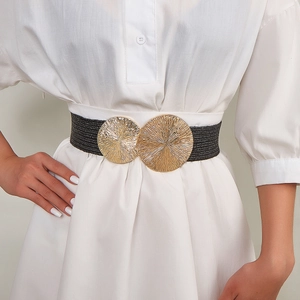 Women's black woven elastic belt with a large circular gold buckle on a white dress
