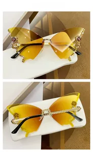 Detail view of butterfly rimless sunglasses with gradient yellow lenses and rhinestones