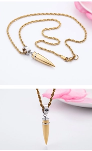 Detailed macro view of two-tone gold bullet pendant with small inlaid crystal on rope chain