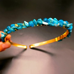 Detail view of handmade blue crystal crown showing intricate gold wire wrapping and stones