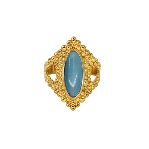 Close-up of retro gold ring with oval blue gemstone and intricate beaded metalwork