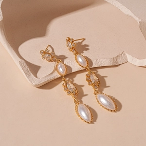 Detailed macro view of vintage gold tassel earrings with marquise pearls and zircon crystals