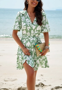 Detail of green summer shirt dress featuring white leaf print and elegant ruffled hemline