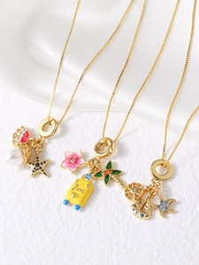 Close-up of gold-plated necklaces with starfish, pearl, and enamel travel pendants