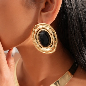 Close-up of a large vintage oval earring with gold metal frame and black center stone