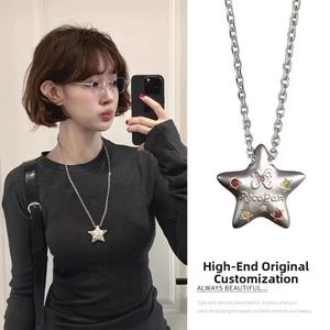 Detail of star-shaped pendant with colorful cubic zirconia and brand engraving
