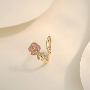 Detail of elegant gold rose ring with pink enamel petals and sparkling zircon accents