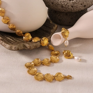 18k gold plated stainless steel shell necklace and pearl drop earrings set on fabric