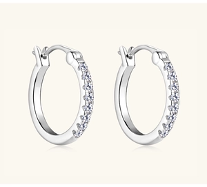 Macro detail of silver S925 sterling silver hoop earrings featuring pavé moissanite stones