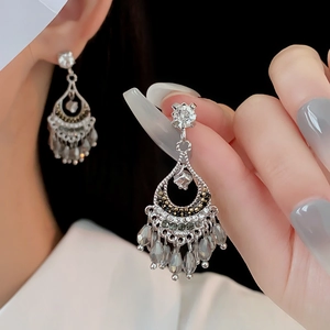 Détail de boucles d'oreilles goutte argentées avec perles grises en style vintage
