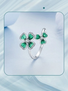 Detail of s925 silver clover open ring with green petals and sparkling diamond accents