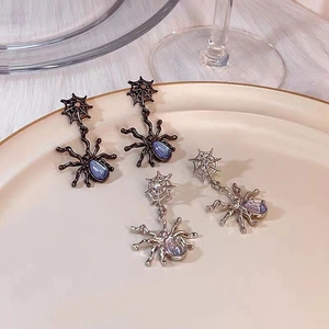 Close-up of gothic spider drop earrings with moonstone insets in black and silver