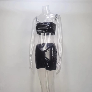 Détail du haut bandeau court en PVC noir brillant et de la mini-jupe moulante en vinyle