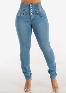 Detail of high waisted blue skinny jeans with five-button fly and elastic pleated waist