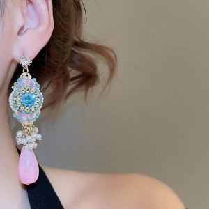 Close-up of elegant resin shell floral tassel earrings with pearls on model