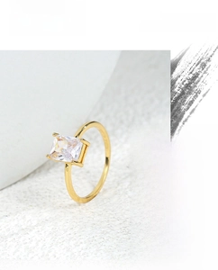 Close-up of minimalist 18K gold ring featuring a rectangular zircon in a four-prong setting