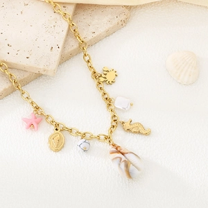 Detailed flat lay of golden ocean themed necklace with seashell and starfish pendants