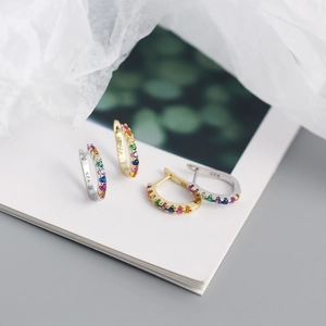Detailed macro view of S925 sterling silver U-shaped earrings with colorful zircon stones
