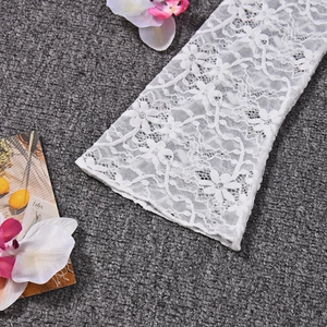 Detailed close-up of white floral hollow lace sleeve texture on a semi-transparent top