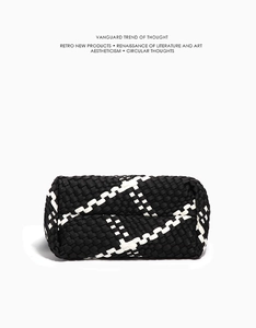 Detailed bottom view of the black and white woven leather tote bag with grid texture
