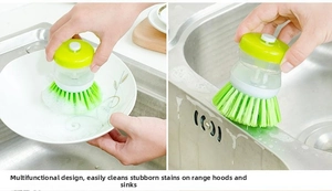 Detail of automatic soap dispensing pot brush cleaning ceramic plates and sinks