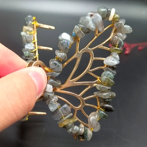 Detailed view of handmade butterfly hair claw with grey-blue natural stones and gold metal