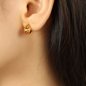 Elegant gold teardrop stud earrings in polished titanium steel on model ear